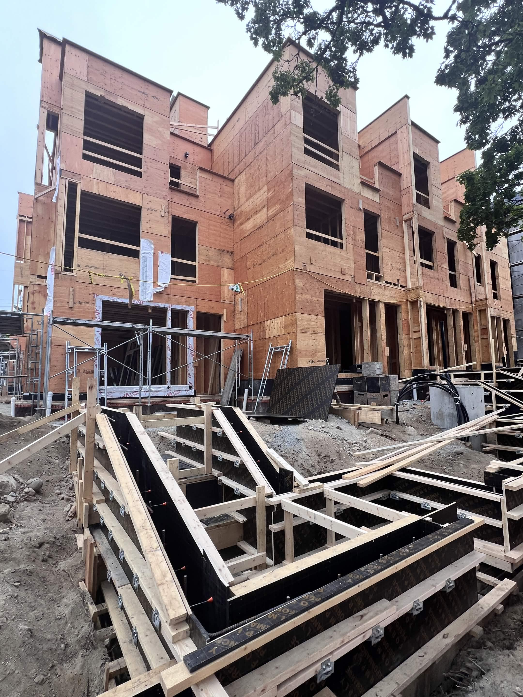 5311 Cypress St sixplex plywood sheathing with window openings and concrete formwork